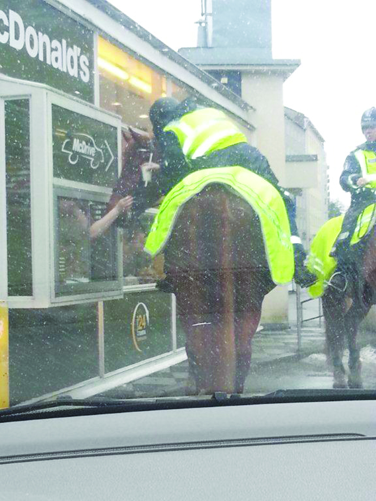 Police officer on horseback queuing at a McDonald's in Helsinki, Finland