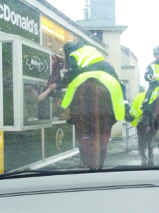 Police officer on horseback queuing at a McDonald's in Helsinki, Finland