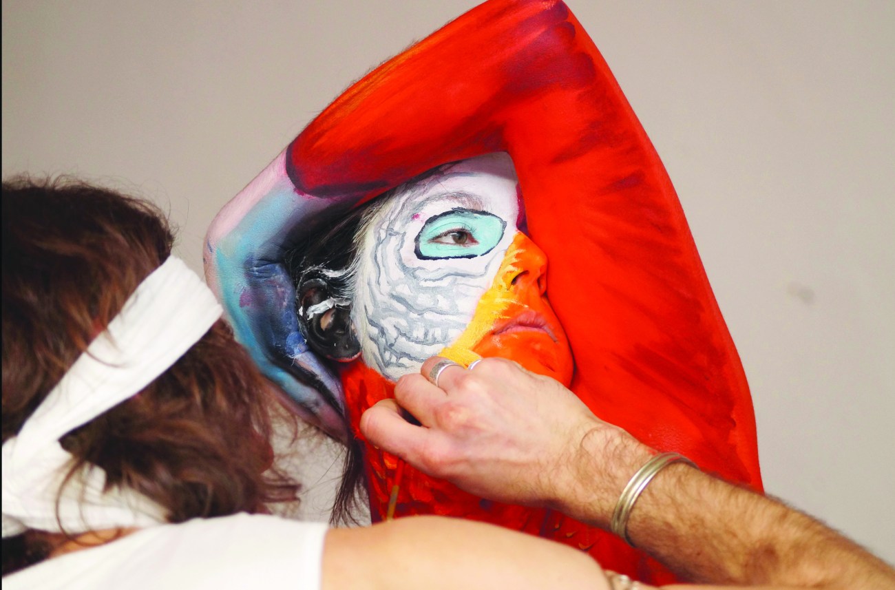 Bodypainter paints woman to look like a parrot, Italy - Mar 2014