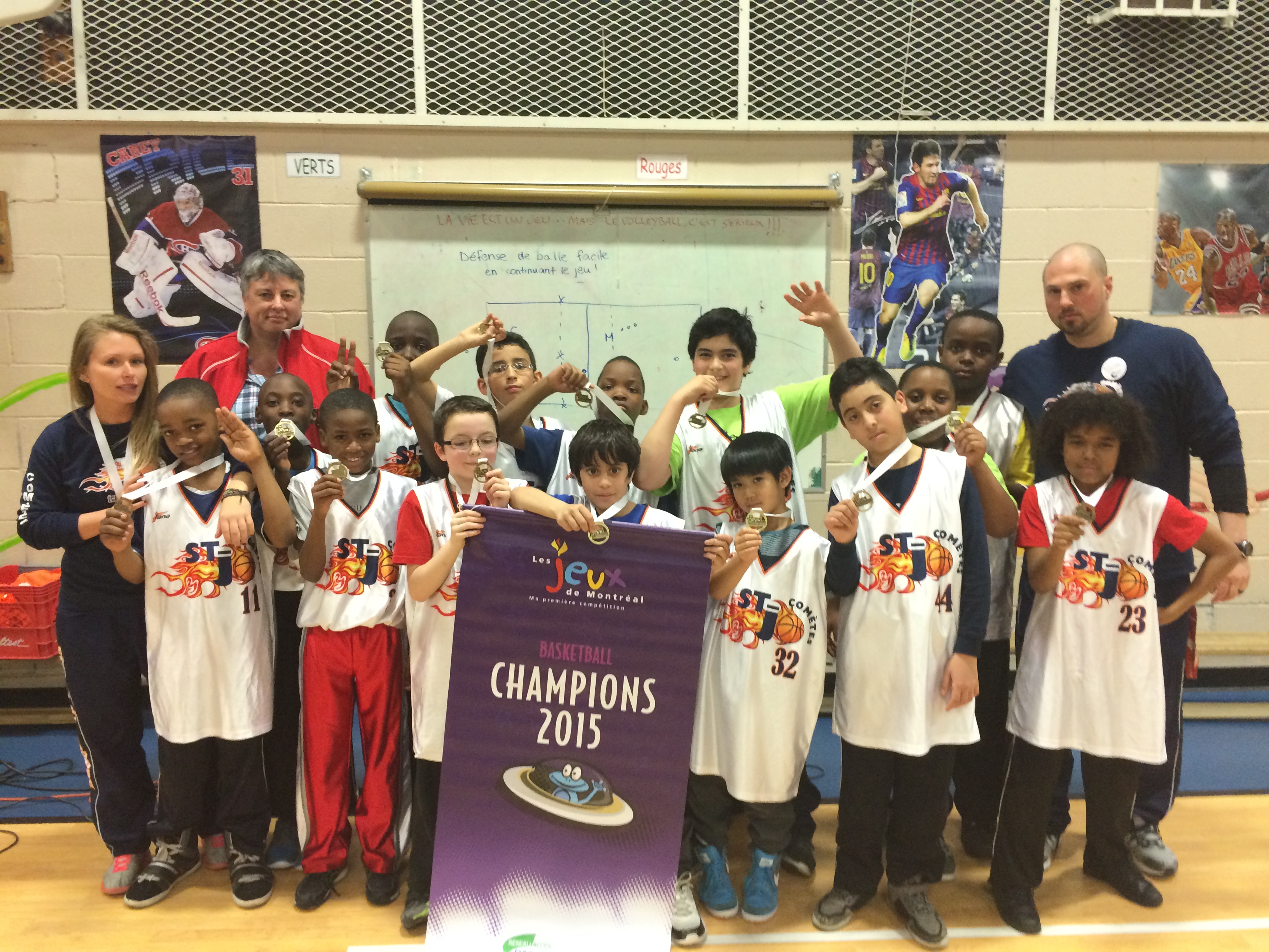 Les repr&eacute;sentants de l'arrondissement d'Anjou en mini-basketball aux Jeux de Montr&eacute;al, les Com&egrave;tes de Saint-Joseph, ont fait tourner bien des t&ecirc;tes en remportant la m&eacute;daille d'or. Les joueurs posent en compagnie de leurs entra&icirc;neurs et de Chantal Massy (en arri&egrave;re-plan), agente de d&eacute;veloppement de l'arrondissement angevin. 