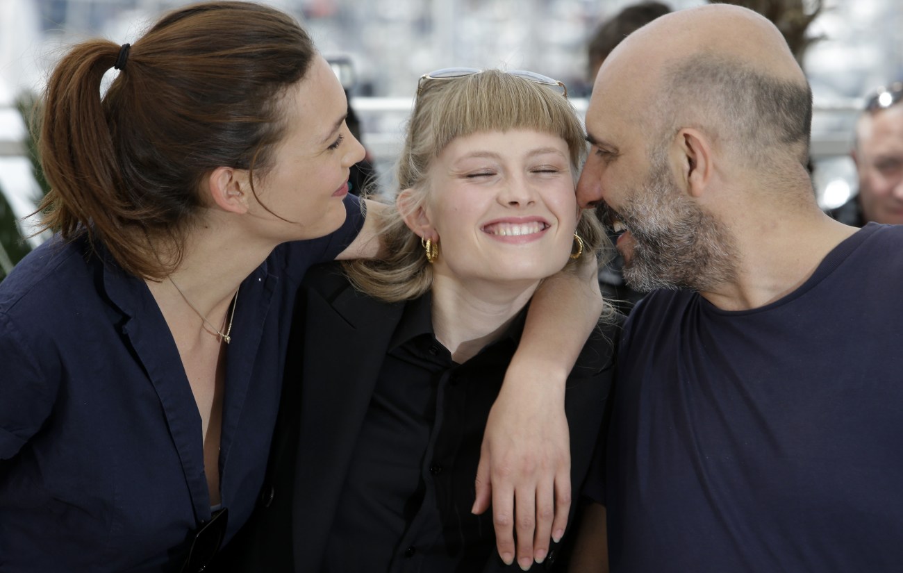 Actors Aomi Muyock, left, Klara Kristin, center, and director Gaspar Noe pose for photographers during a photo call for the film Love, at the 68th international film festival, Cannes, southern France, Thursday, May 21, 2015. (AP Photo/Lionel Cironneau)