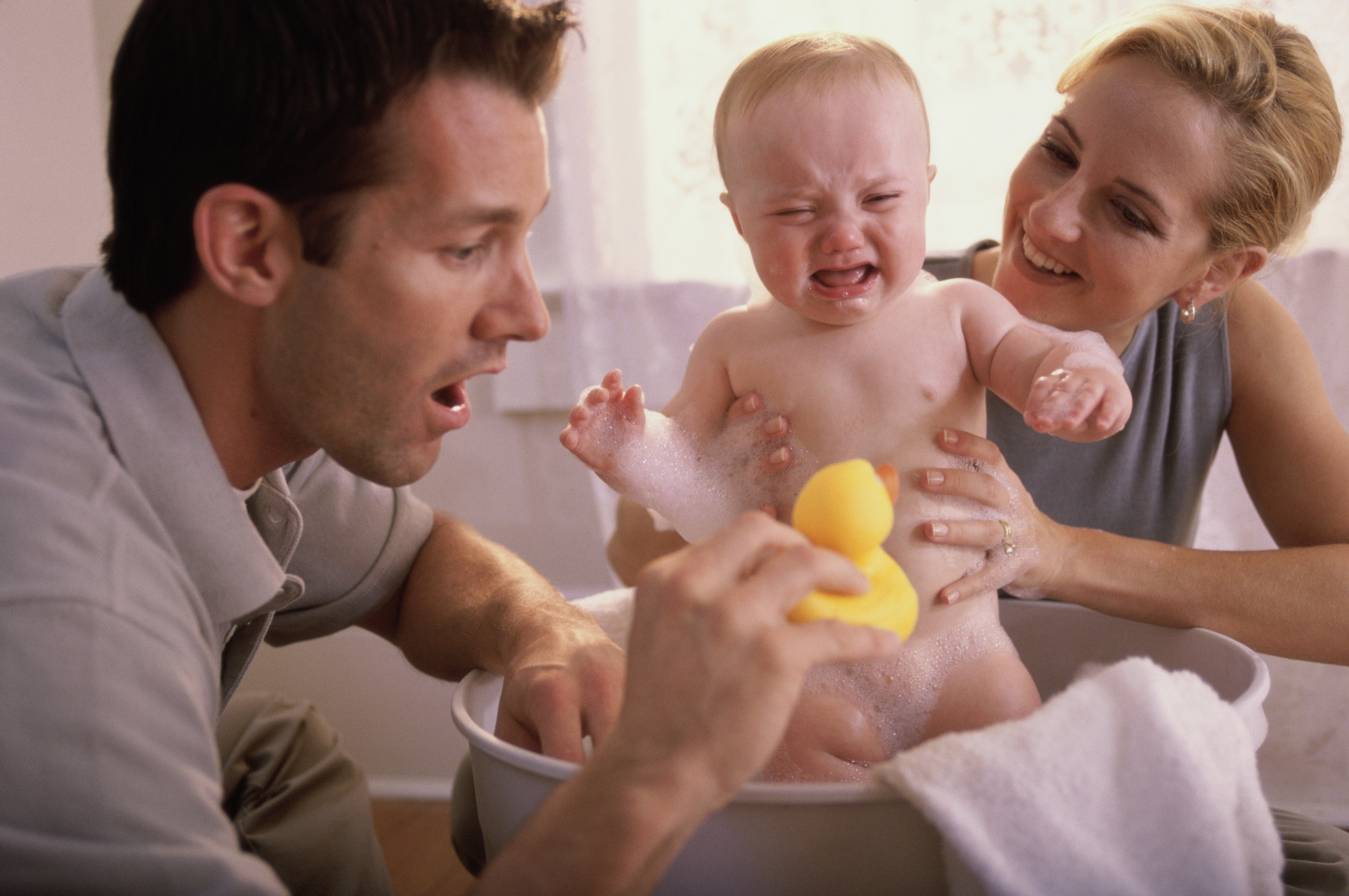 Close-up of parents giving their son a bath