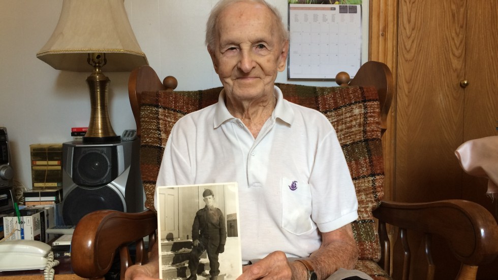 Charles-Édouard Gauthier pose avec une photo prise en 1941 à la sortie de son service militaire à Sherbrooke.