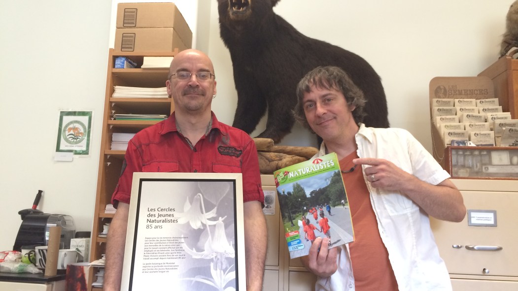 André St-Arnaud et André Cyr posent devant une des mascottes des CJN depuis 1984, l'ours Bruno le Grognon.