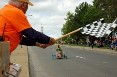 Co-founder of the Dorval Soapbox Derby, Jean-Guy Aubry, waves the checkered flag at the finish line on Fénelon Blvd. on Sunday, Sept. 11.