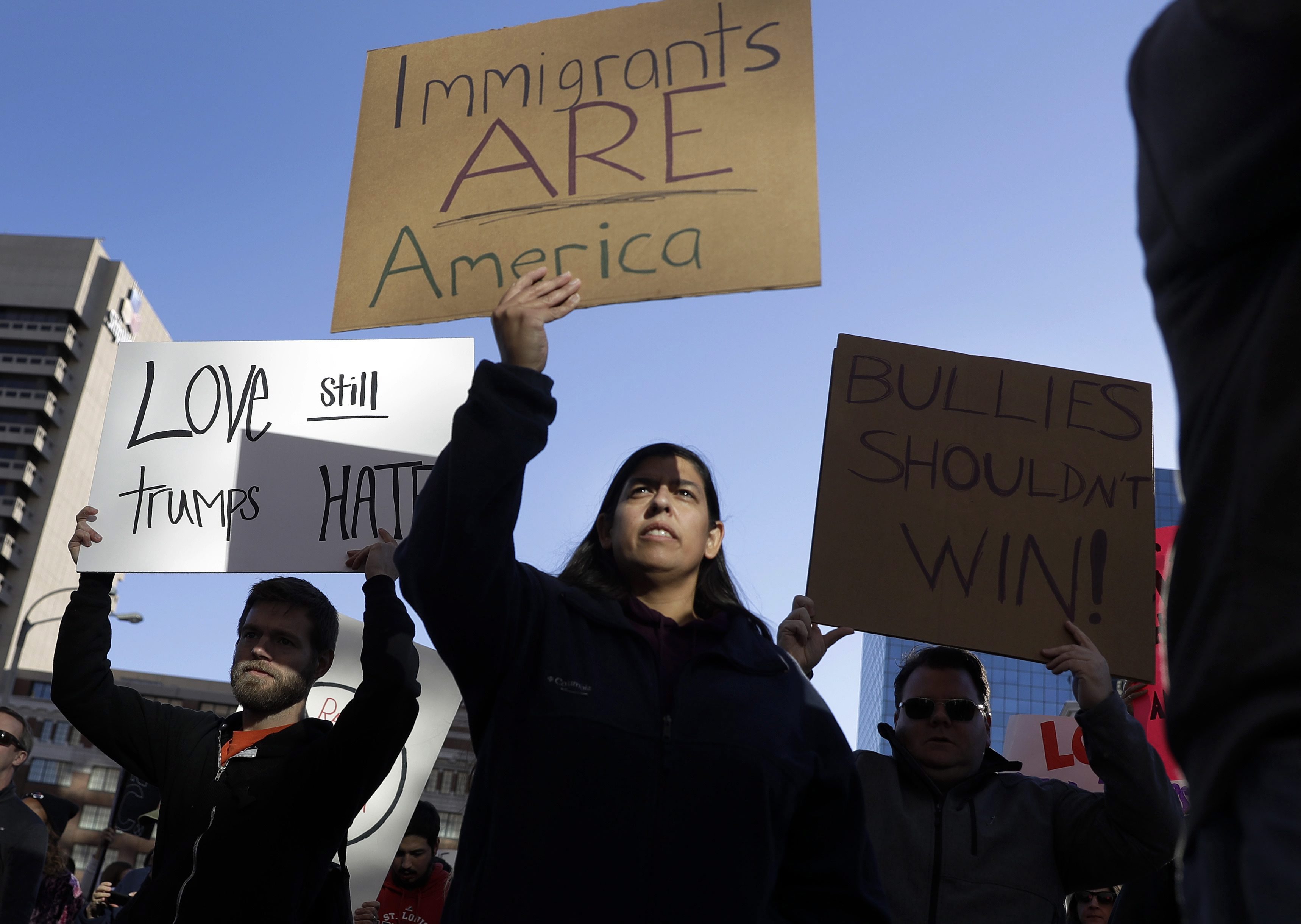 Protesters hold signs as they march in opposition to the election of President-elect Donald Trump on Sunday, Nov. 13, 2016, in St. Louis. Demonstrations also took place internationally. A group of Mexicans at statue representing independence in Mexico City expressed their concerns about a possible wave of deportations. (AP Photo/Jeff Roberson)