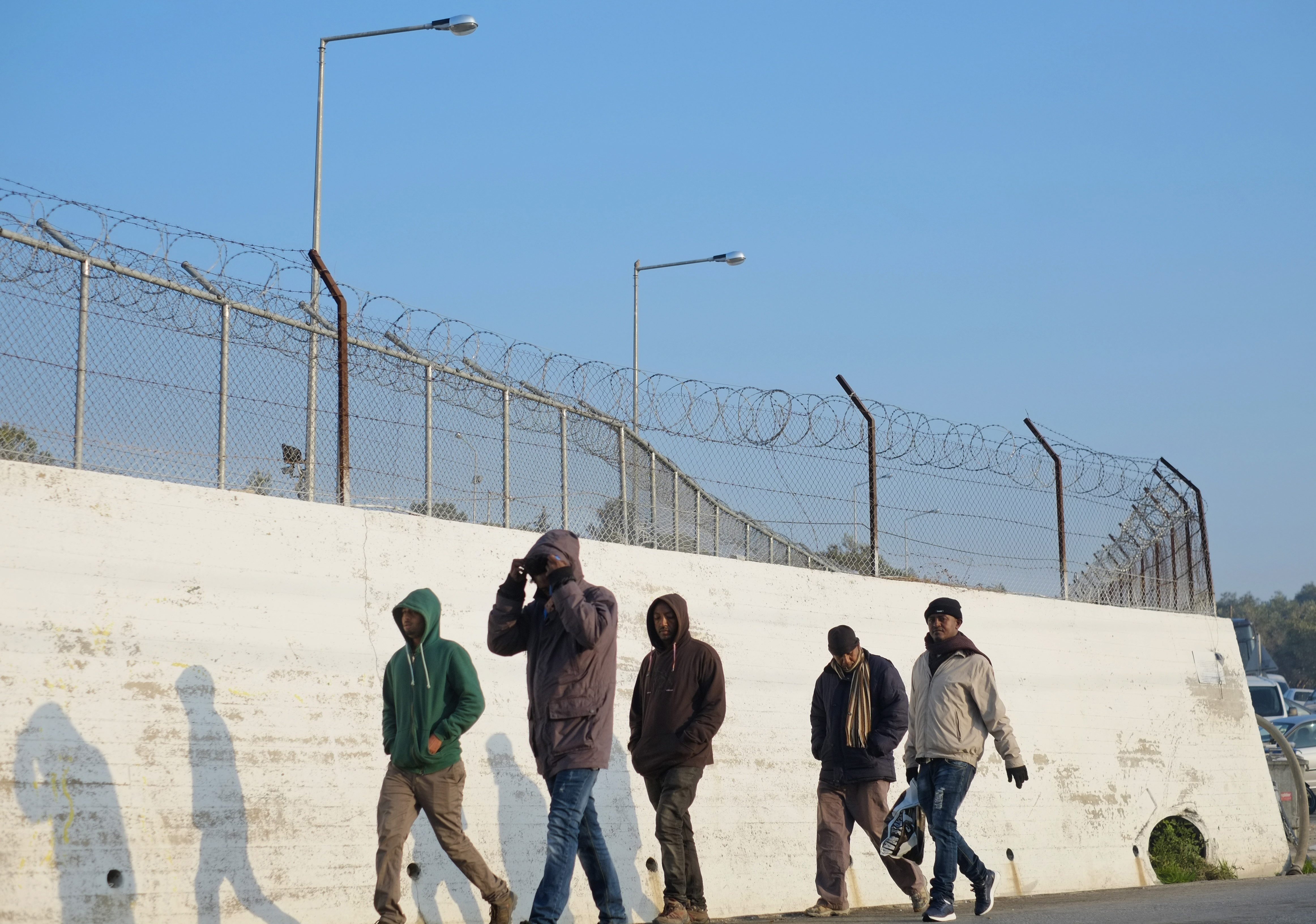 Des réfugiés marchent à l'extérieur du camp de réfugiés de Moria, sur l'île de Lesbos, au nord-est de la Grèce.