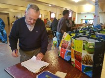 Brian Cadoret reads names from a list of registered users at the food bank in the basement of the Resurrection of Our Lord Church on Tuesday, Oct. 23, 2016.