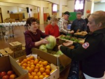 Tracy-Lee Woods gets fresh produce from volunteers at the food bank in the basement of the Resurrection of Our Lord Church on Tuesday, Oct. 23, 2016.