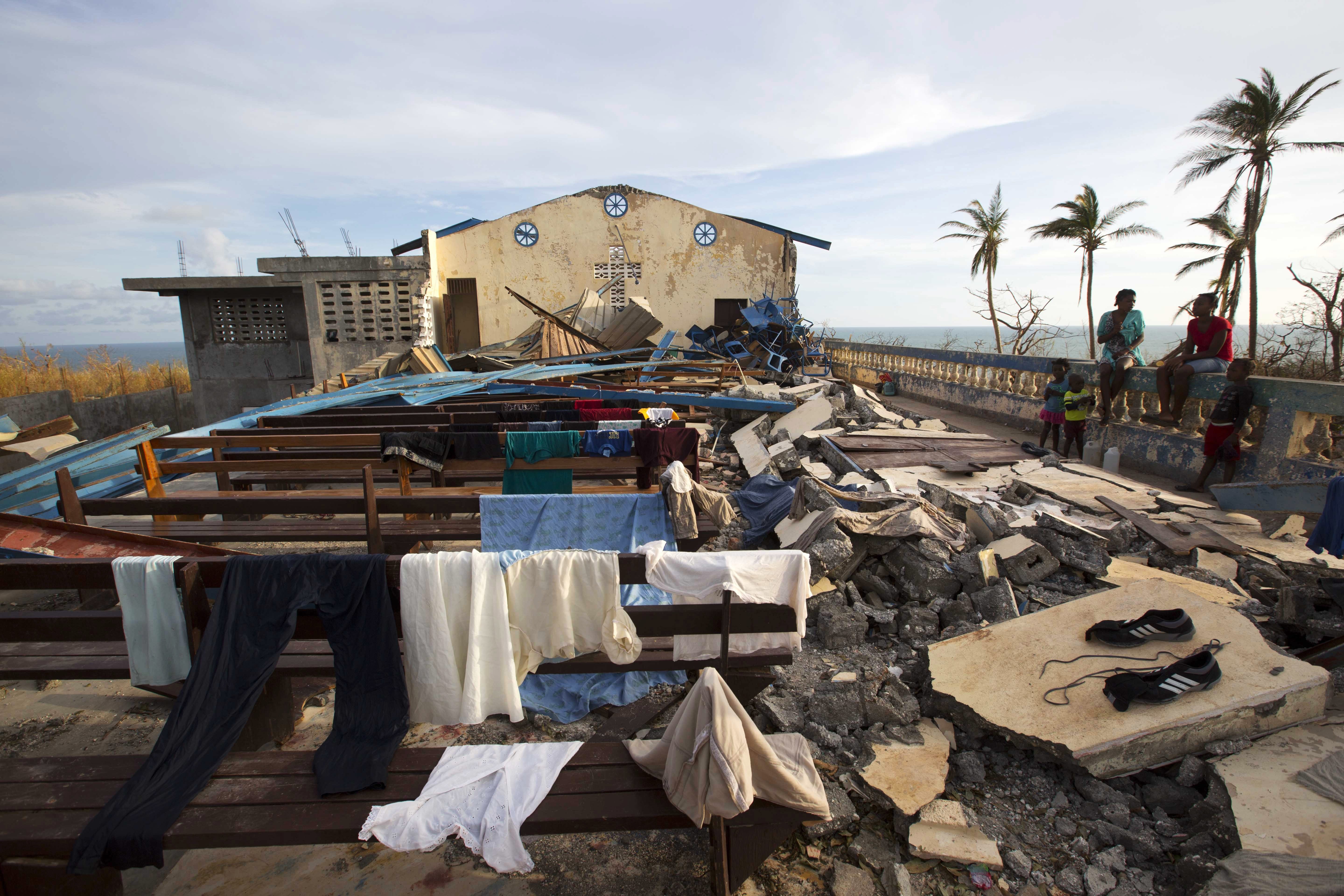 Residents dry clothes at a church that was destroyed by Hurricane Matthew in Jeremie, Haiti, Sunday, Oct. 9, 2016. Jeremie appears to be the epicenter of the country's growing humanitarian crisis in the wake of the storm. ( AP Photo/Dieu Nalio Chery)