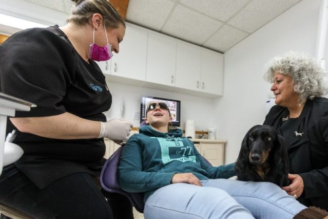 Une assistante dentaire qui a du chien
