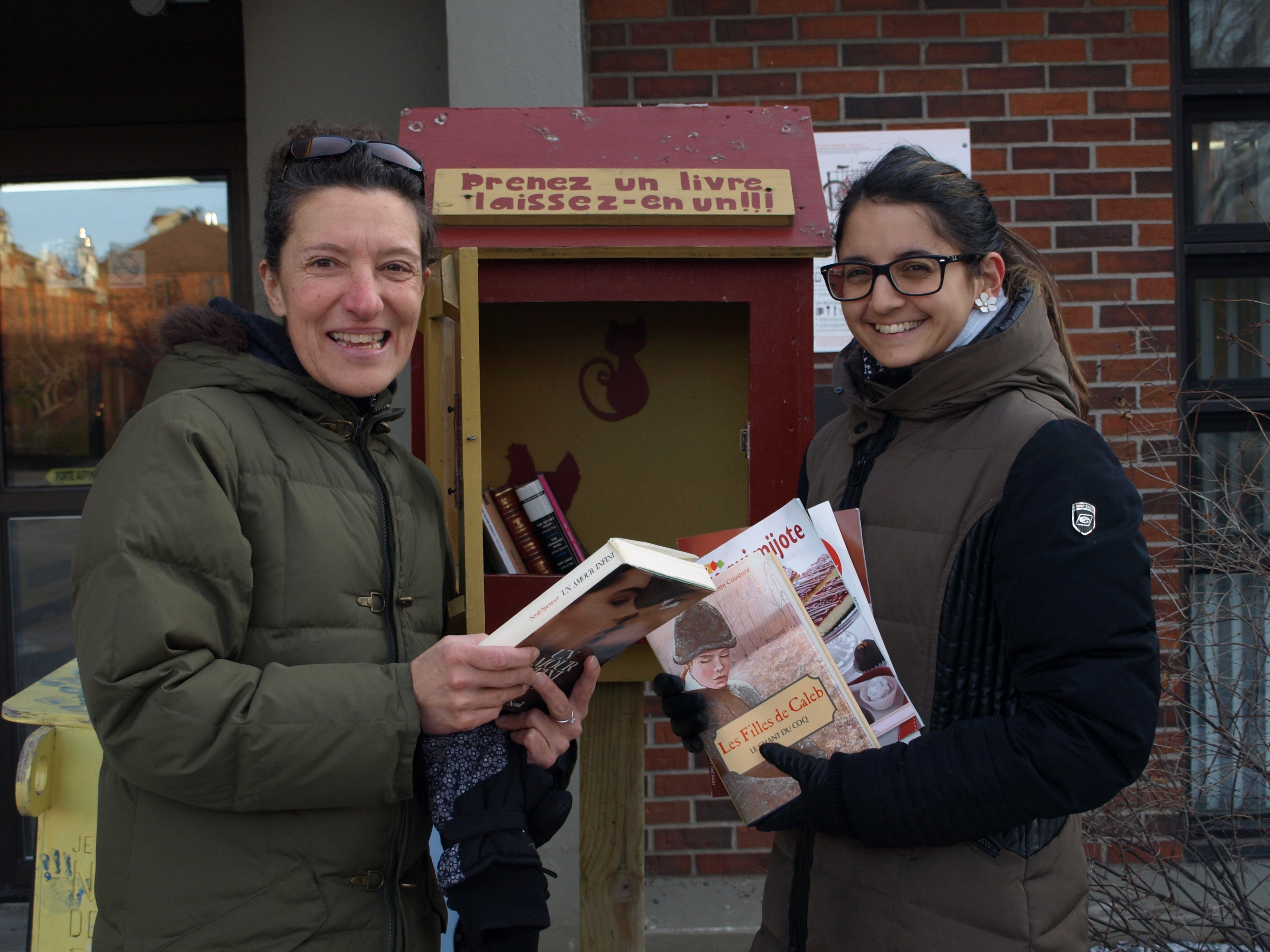 Lyne Drouin et Marie-Noëlle Dufour Boivin, du comité priorité culture, à côté d'une des premières bibliothèques libre-service de Rosemont.