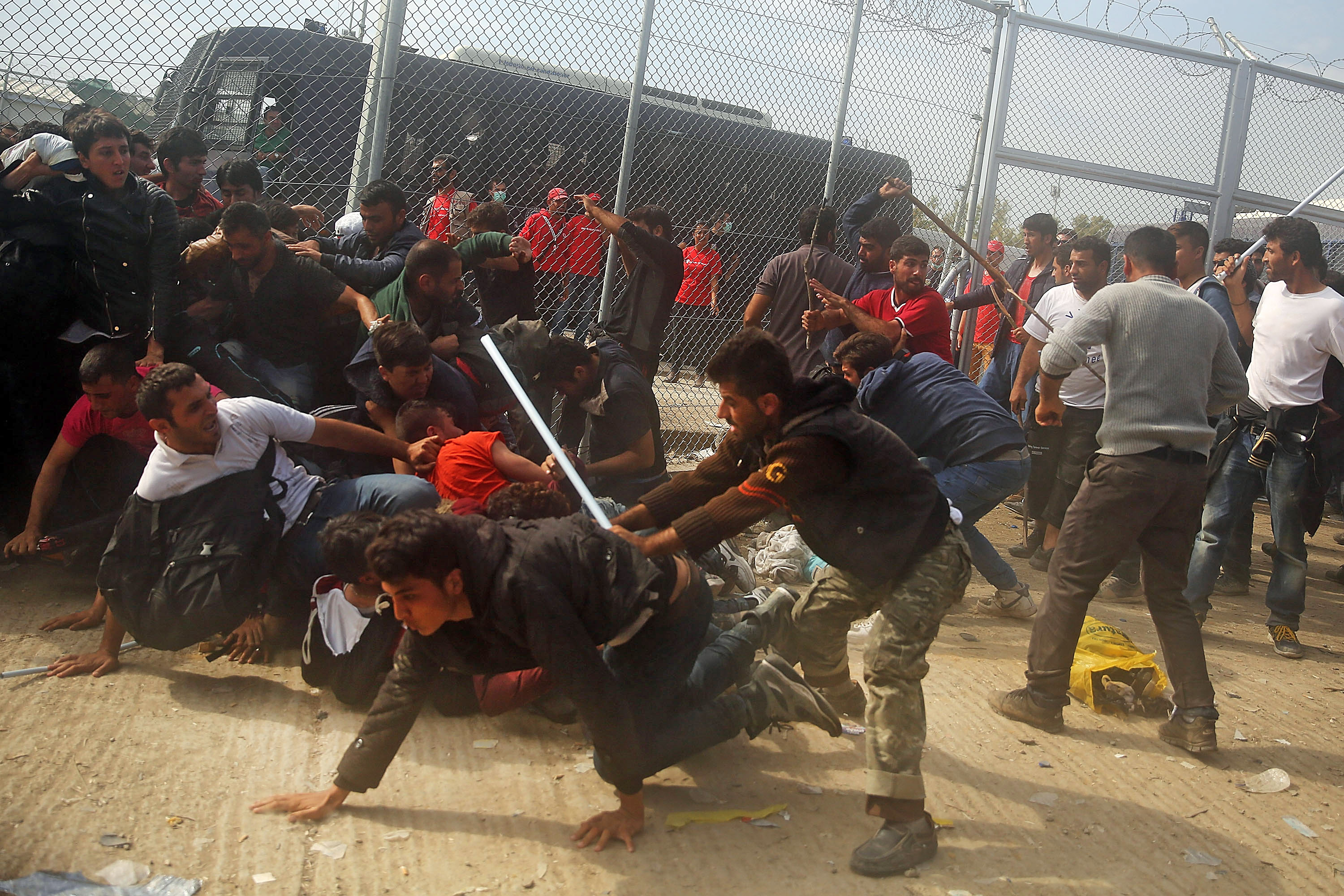 MYTILENE, GREECE - OCTOBER 20: People flee from Afghan men with sticks as they fight with other recently arrived migrants waiting to be processed at the increasingly overwhelmed Moria camp on the island of Lesbos on October 20, 2015 in Mytilene, Greece. Dozens of rafts and boats are still making the journey daily as thousands flee conflict in Iraq, Syria, Afghanistan and other countries. More than 500,000 migrants have entered Europe so far this year. Of that number, four-fifths have paid to be smuggled by sea to Greece from Turkey, the main transit route into the EU. Nearly all of those entering Greece on a boat from Turkey are from the war zones of Syria, Iraq and Afghanistan. (Photo by Spencer Platt/Getty Images)
