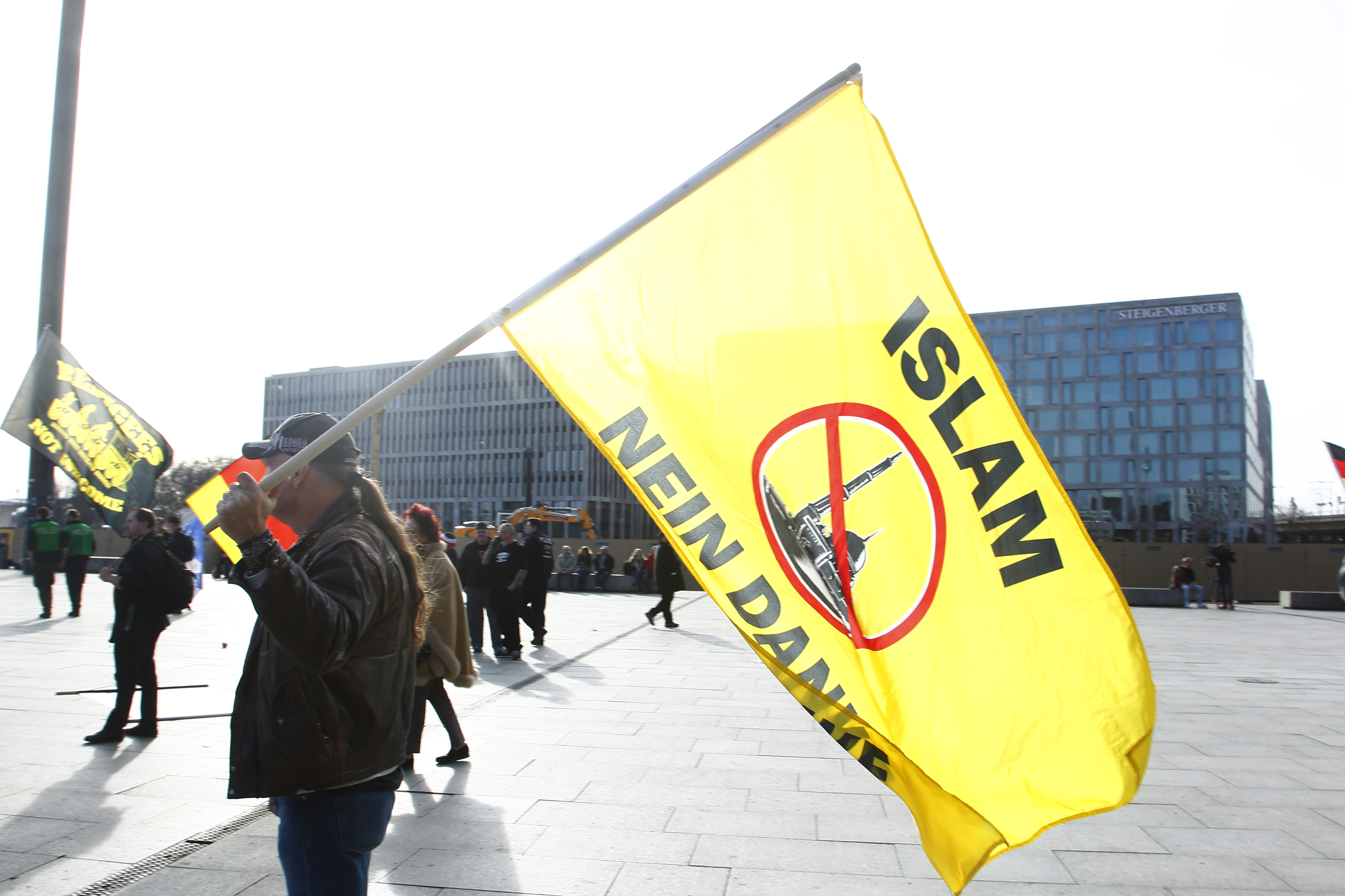 BERLIN, GERMANY - MARCH 04:Protesters hold Germany Flag and Placard with right wing slogans against the Government and the Muslim religion at a " Merkel muss weg" gathering of right-wing demonstrators who were protesting against German Chancellor Angela Merkel on March 4, 2017 in Berlin, Germany. Germany faces federal elections in September and the right-wing populist Alternative for Germany (AfD) political party has profited from wide-spread discontent over Merkel's open policy towards refugees and migrants. (Photo by Michele Tantussi/Getty Images)