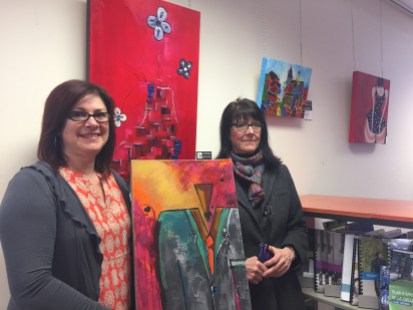 Line Milotte (gauche) et Louise Raymond posent entourée d’œuvres à la bibliothèque de Pointe-aux-Trembles, le 8 mars 2017.