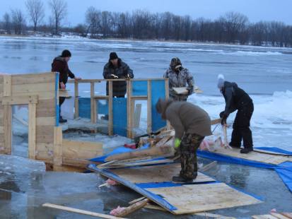 Des membres d'un groupe Facebook démontent et retirent une cabane de pêche de la descente de bateaux située à l'angle de Gouin Est et de la 133e Rue, dans Rivière-des-Prairies, le 6 mars 2017.