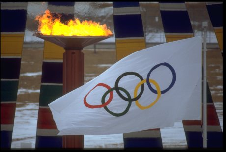 Le drapeau des Jeux olympiques devant la flamme olympique