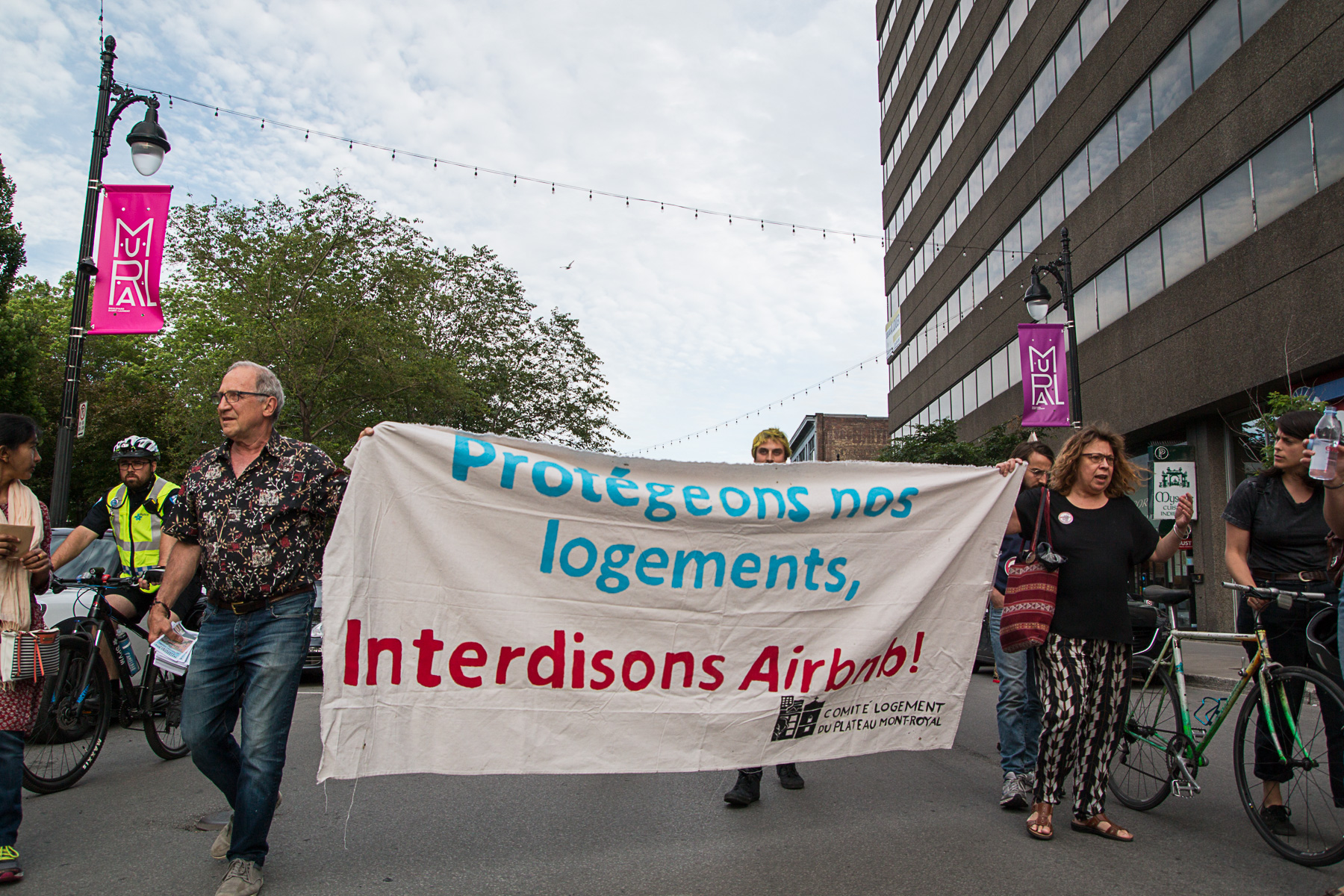 Des manifestants défilent avec une pancarte indiquant «Protégeons nos logements, interdissons Airbnb».