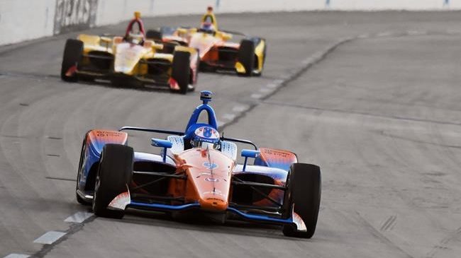 Scott Dixon devance deux concurrents lors d'une course d'IndyCar.