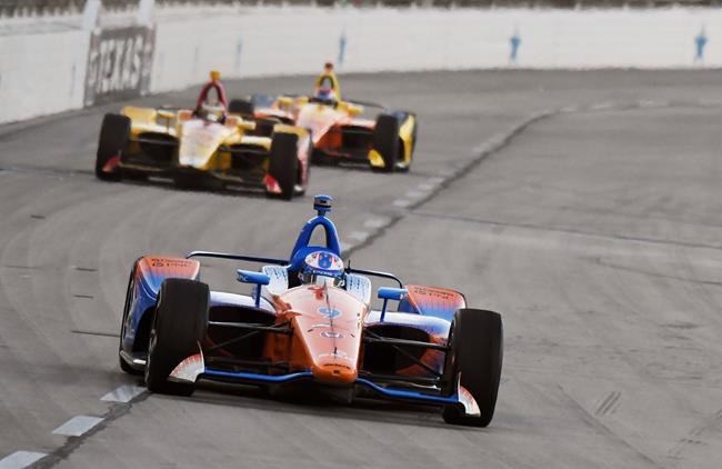 Scott Dixon devance deux concurrents lors d'une course d'IndyCar.