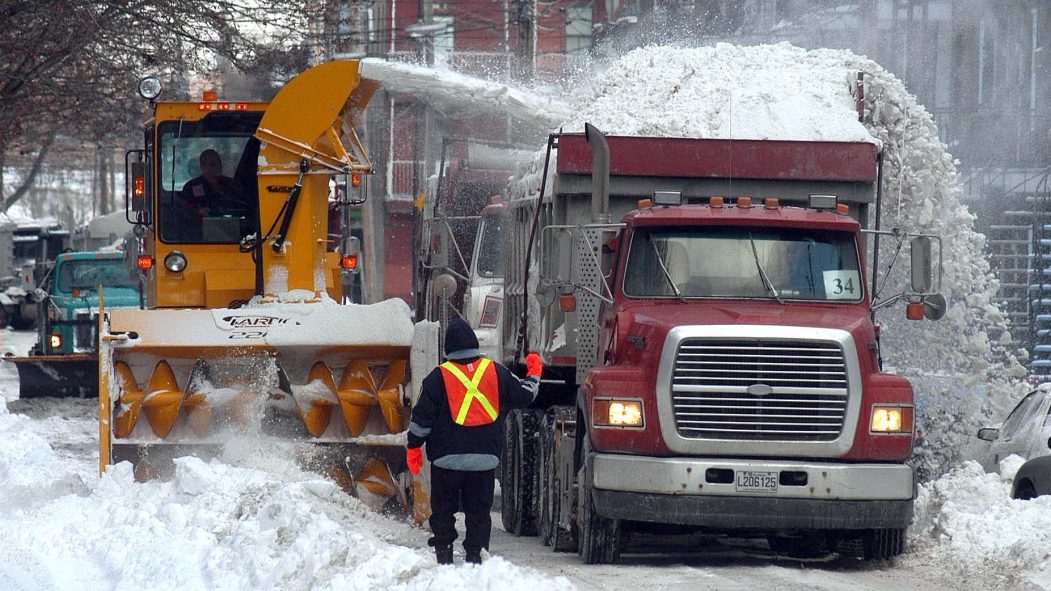 Un camion et une souffleuse pendant une opération de chargement de la neige à Montréal
