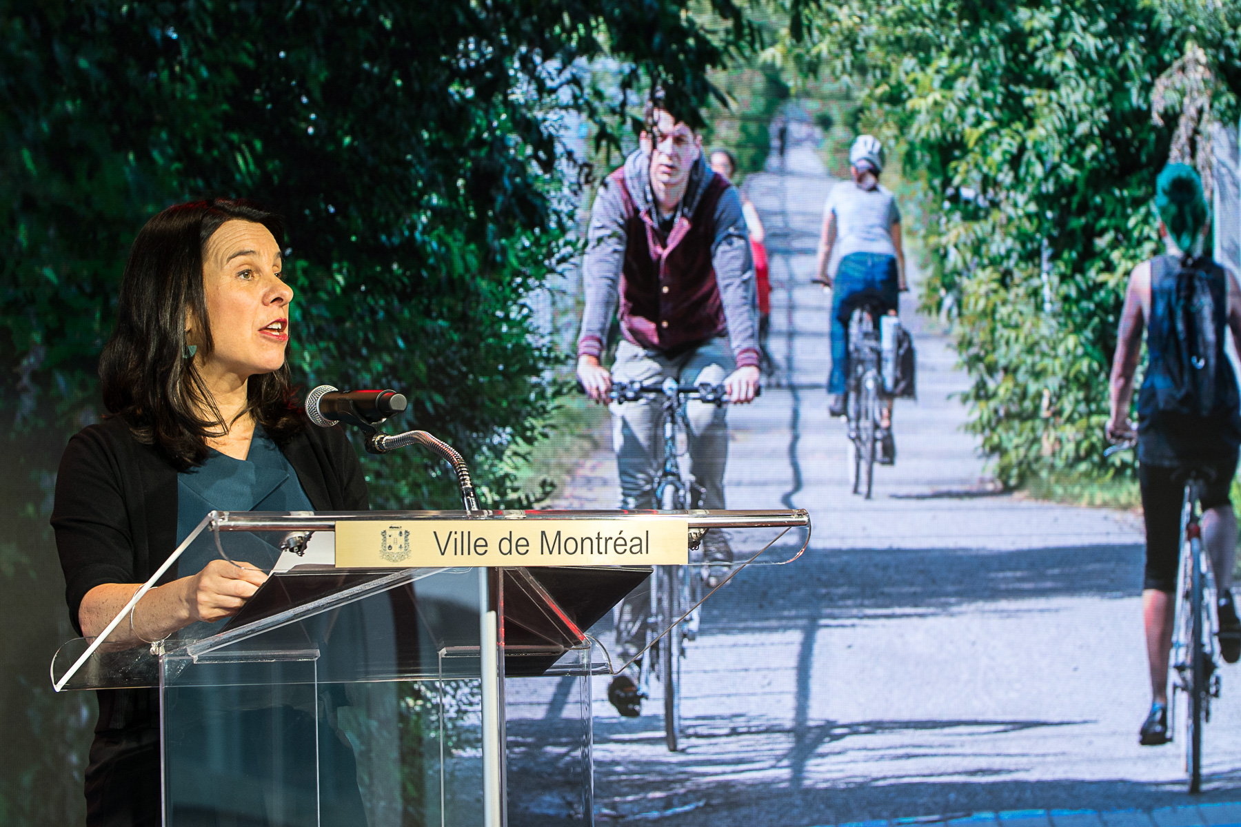 La mairesse Valérie Plante devant une affiche montrant le Réseau express vélo.