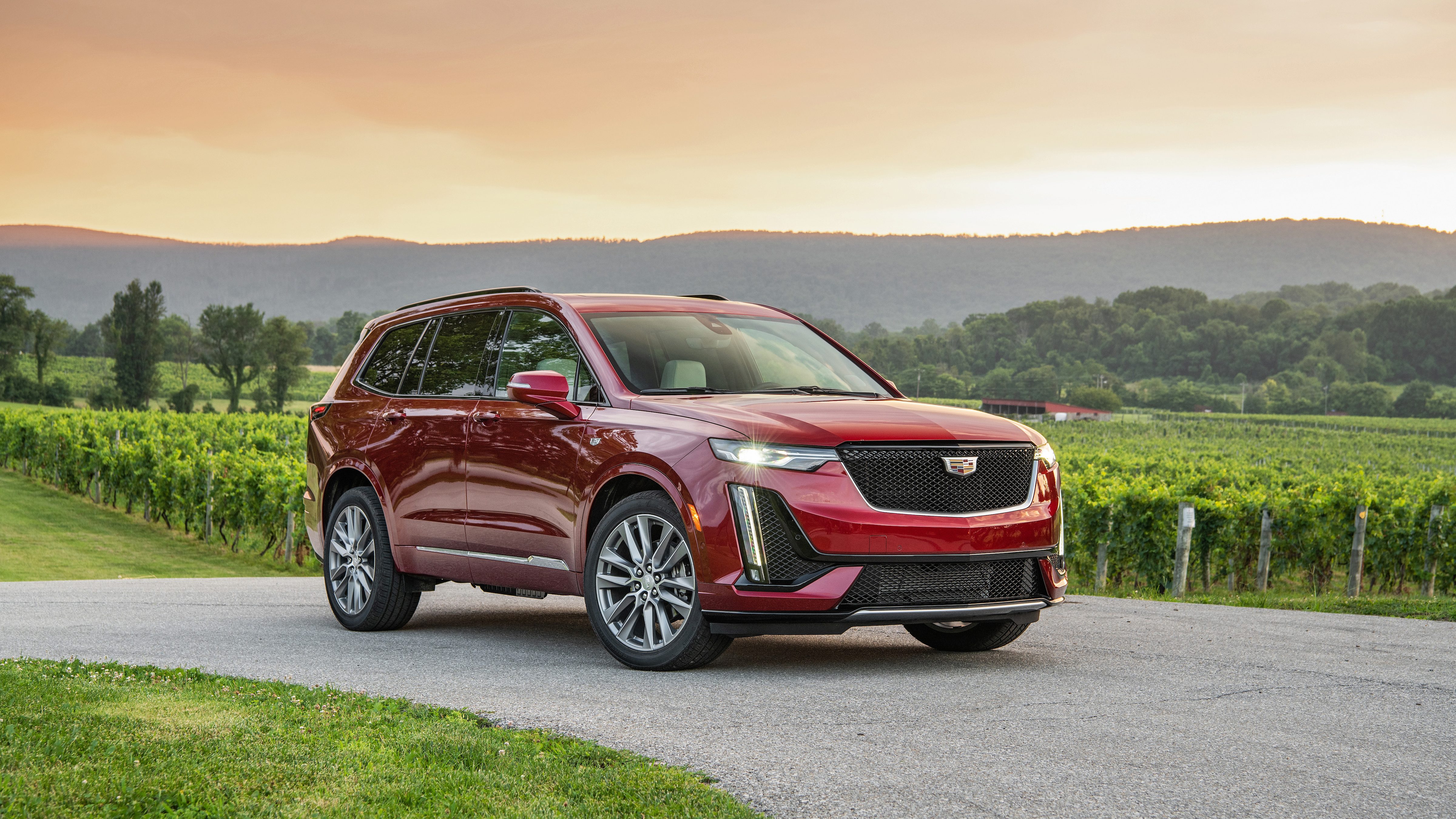 Cadillax XT6 rouge devant paysage montagneux