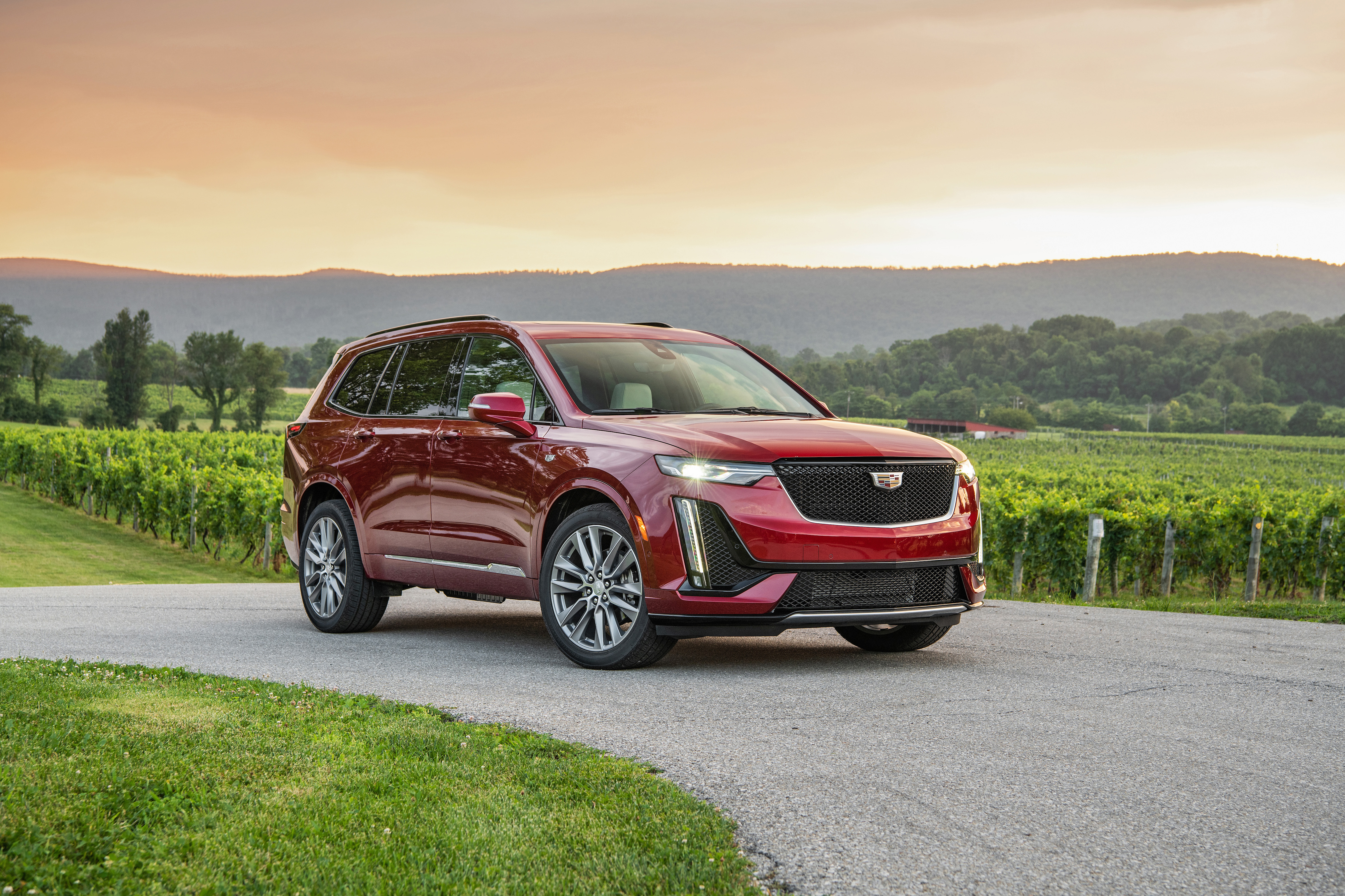 Cadillax XT6 rouge devant paysage montagneux