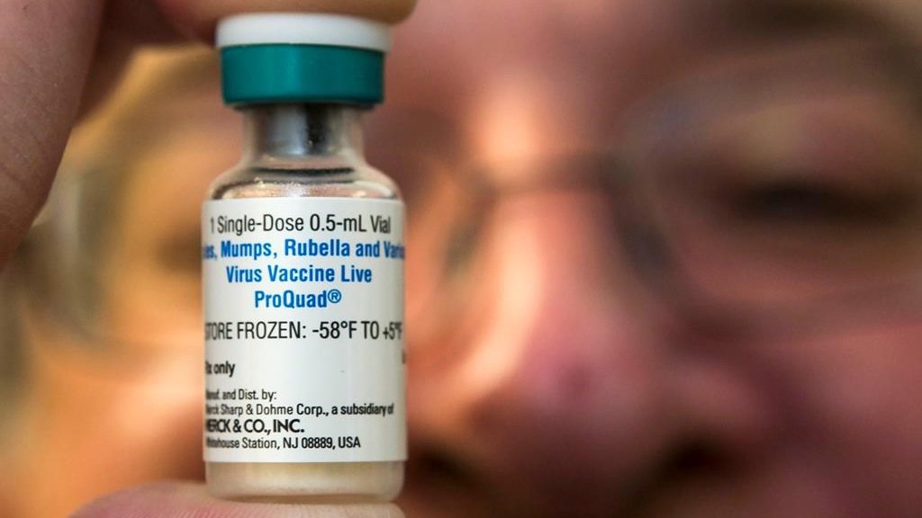 Un pédiatre tenant le vaccin utilisé contre la rougeole.