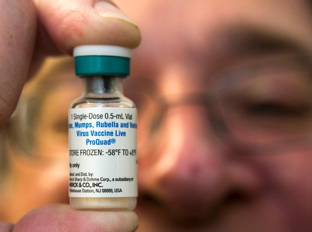 Un pédiatre tenant le vaccin utilisé contre la rougeole.