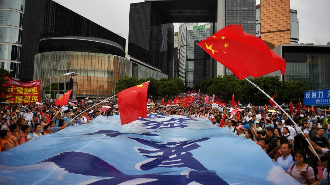 Des partisans pro-Pékin agitent le drapeau national chinois lors d'un rassemblement pro-gouvernemental à Hong Kong