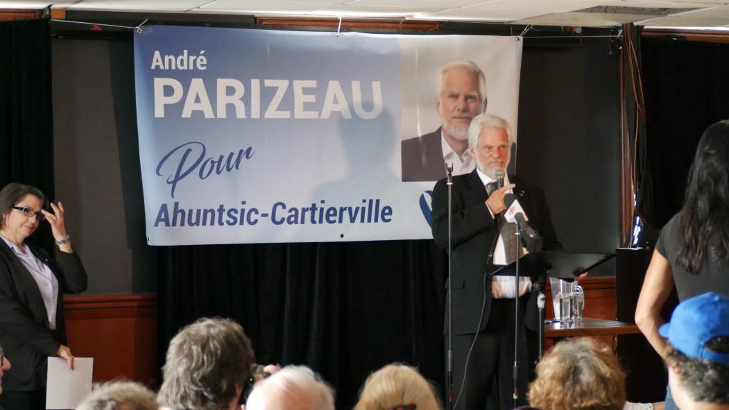André Parizeau, candidat du Bloc québécois devant une affiche à son nom
