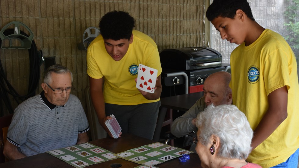 Deux jeunes bénévoles jouent avec des résidents du CHSLD