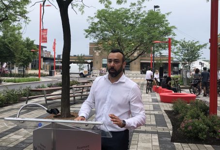 Le directeur général de la SDC Petite-Italie, Jean-Éric Delarosbil, parle derrière un podium lors du dévoilement de la nouvelle place Shamrock.