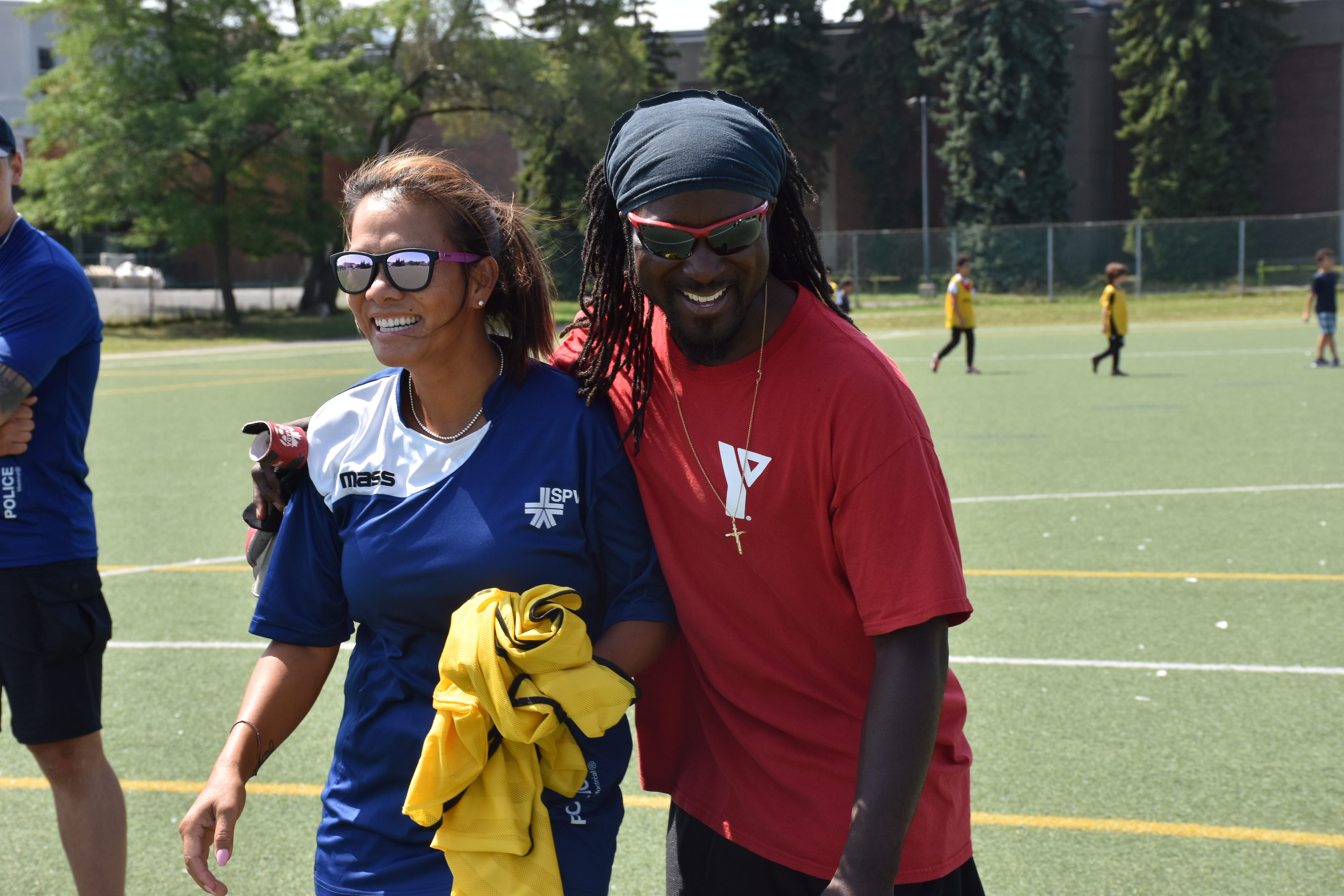 L’agente sociocommunautaire du SPVM, Thi Truc Mai Dang, en compagnie de Fritznel Cazeneuve, intervenant au sein des YMCA du Québec sur le terrain de soccer.