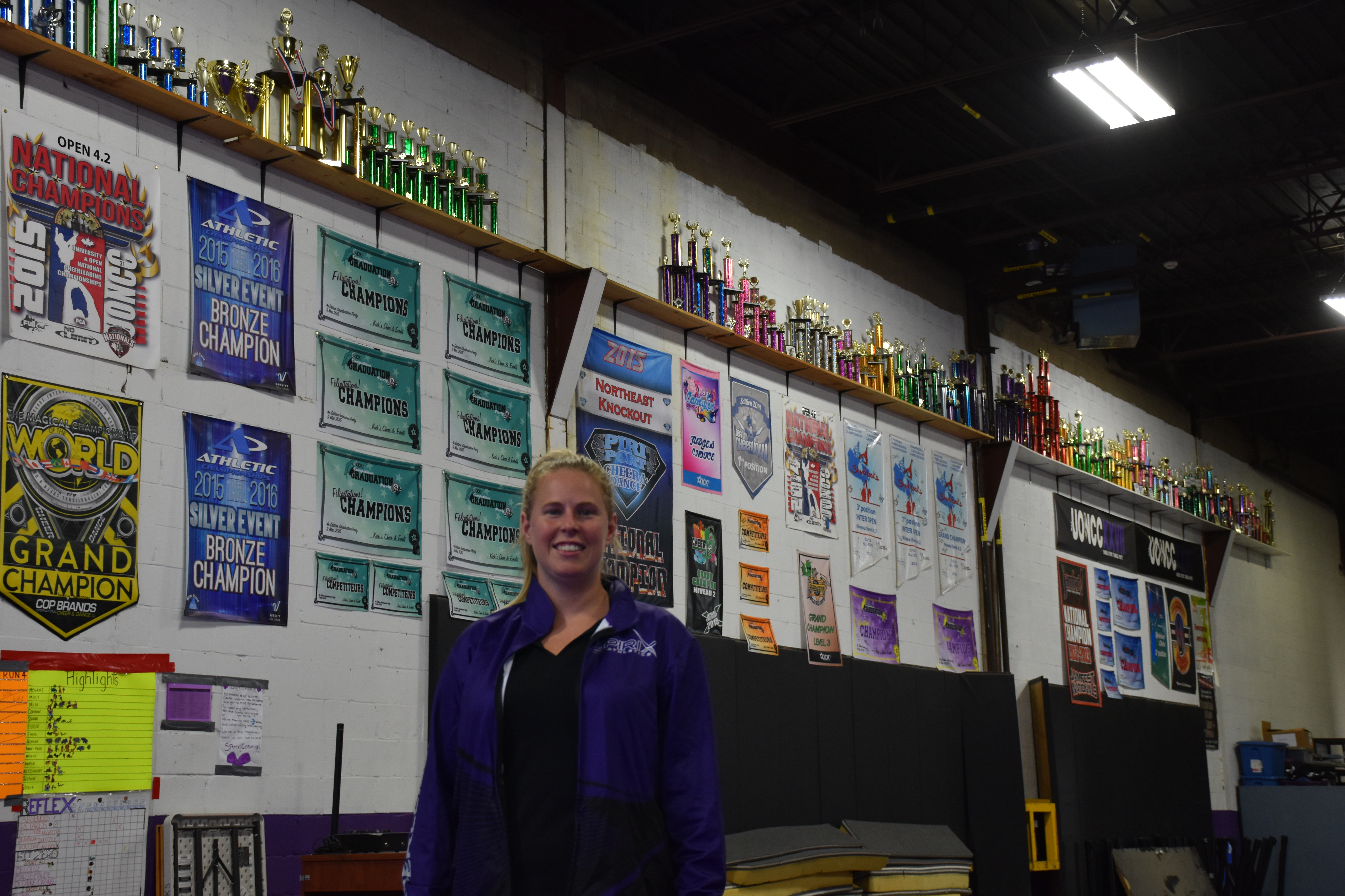 Janie Lapierre, devant un mur couvert de trophées et bannières.