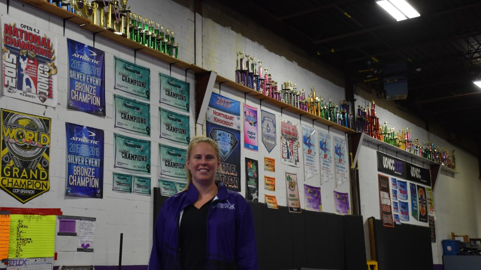 Janie Lapierre, devant un mur couvert de trophées et bannières.