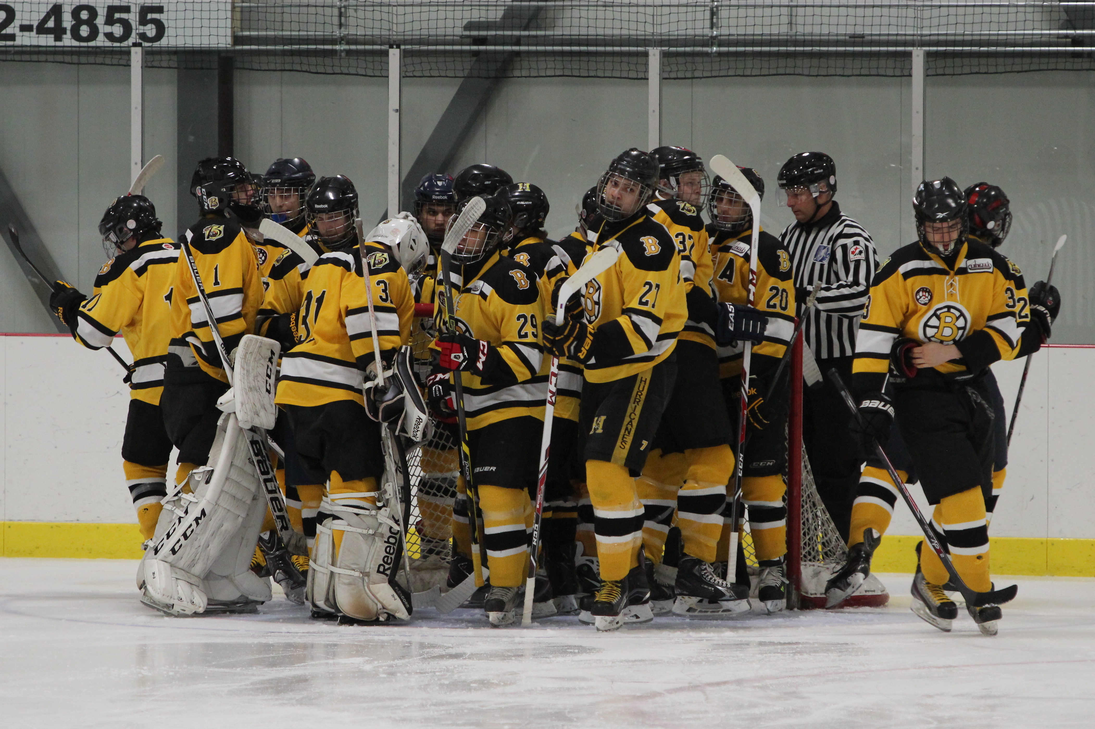 Des joueurs de hockey des Braves d'Ahuntsic rassemblés sur la glace