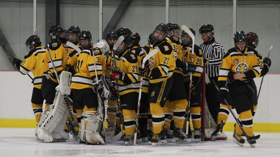 Des joueurs de hockey des Braves d'Ahuntsic rassemblés sur la glace