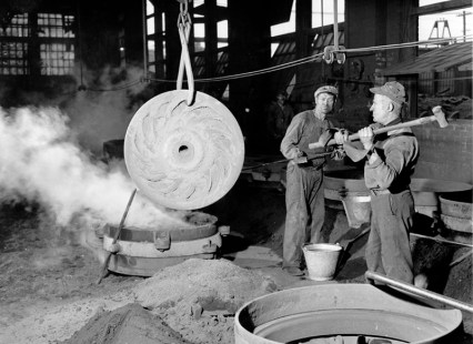 Une image d'époque des shops Angus. Deux travailleurs s'affairent sur une pièce de métal.