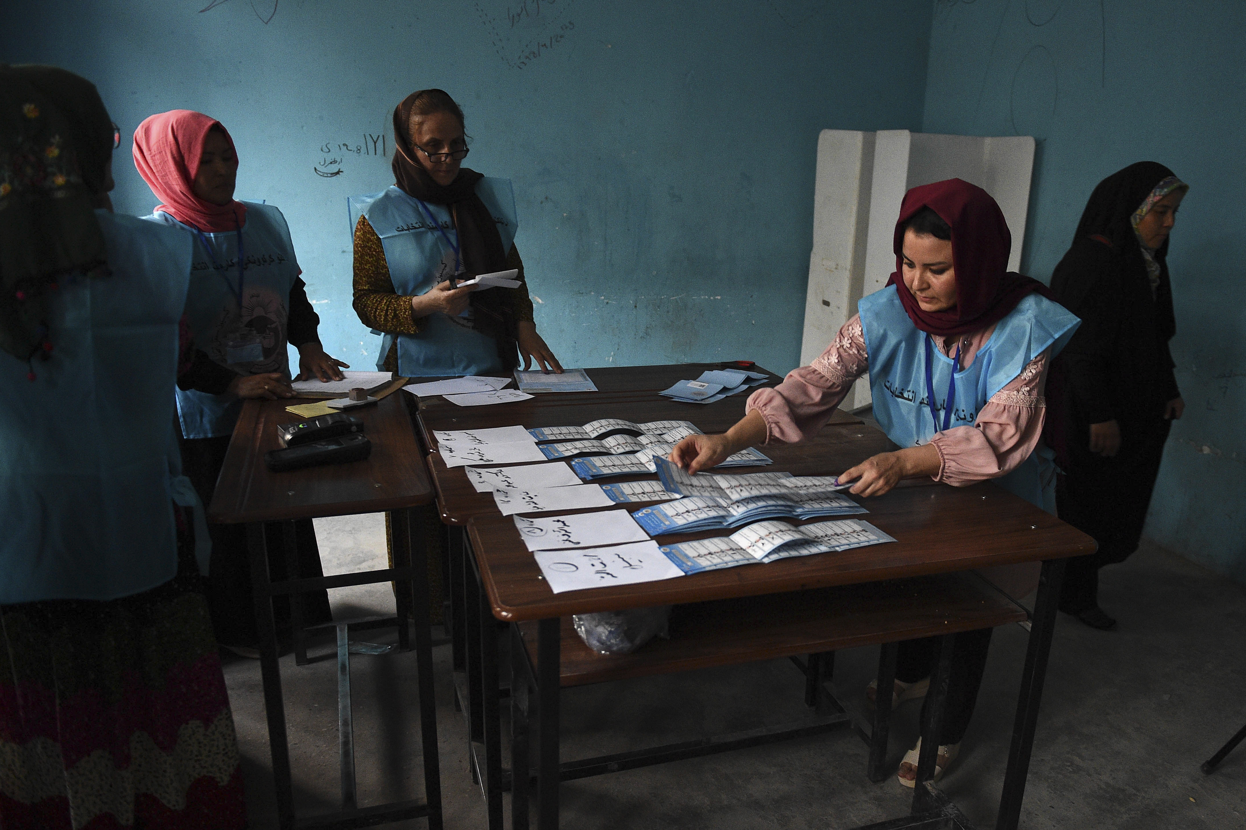 Menacés par des attentats, des Afghans procèdent au dépouillement des bulletins de vote.
