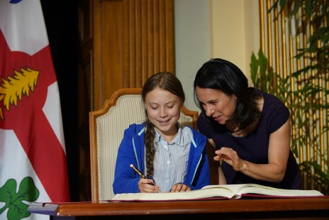 Greta Thunberg signant le livre d'or de la Ville de Montréal, en compagnie de la mairesse Valérie Plante.