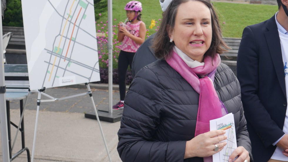 Émilie Thuillier devant un panneau présentant les nouvelles pistes cylables
