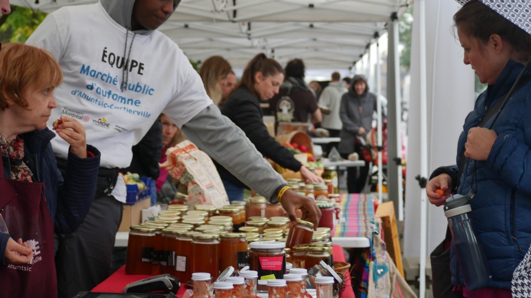 Devant un étal de miel dans le marché public d'automne à Ahuntsic-Cartierville