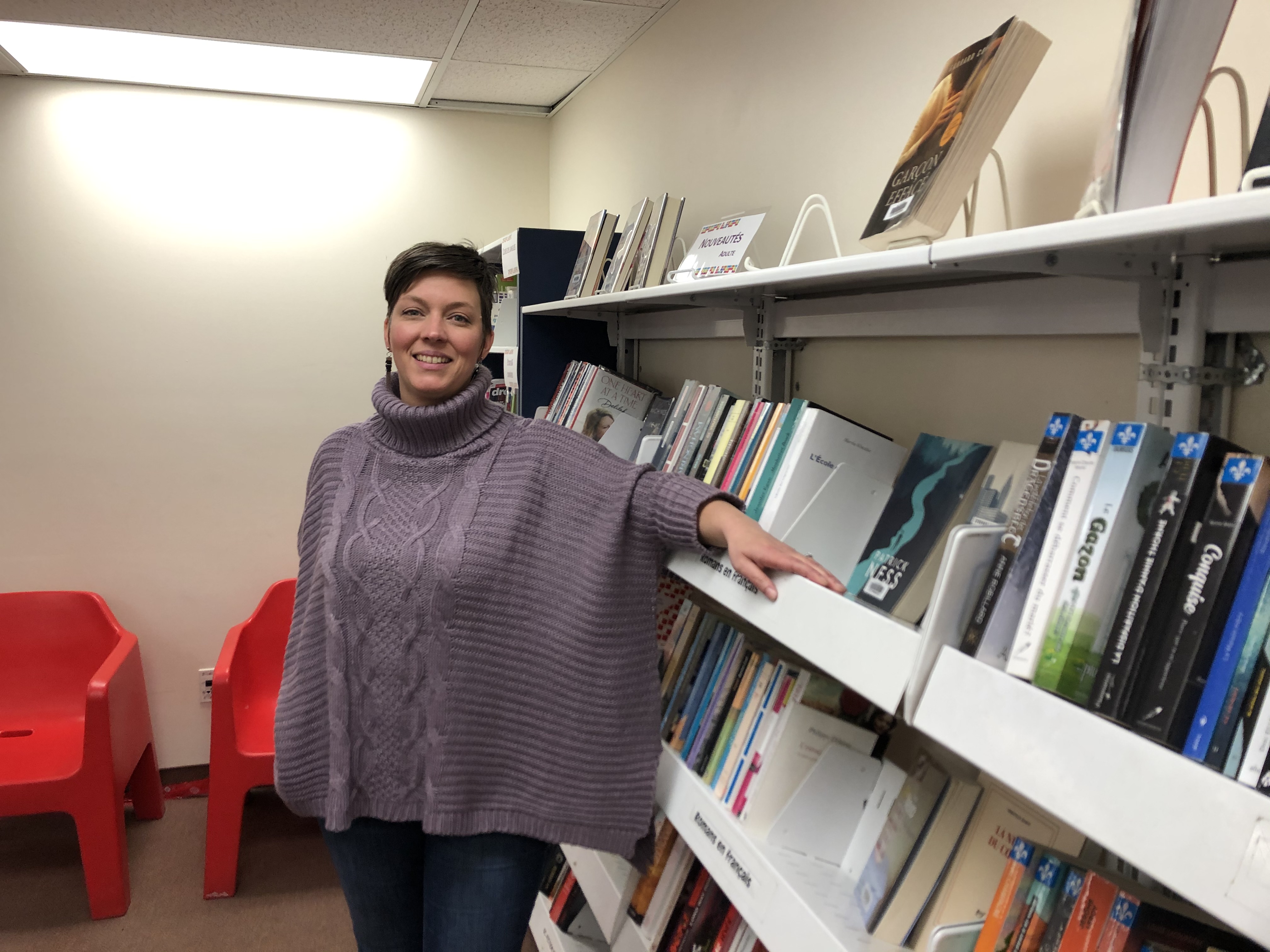 Mélanie Bossé responsable bibliothèque Ahuntsic devant un rayon de livres