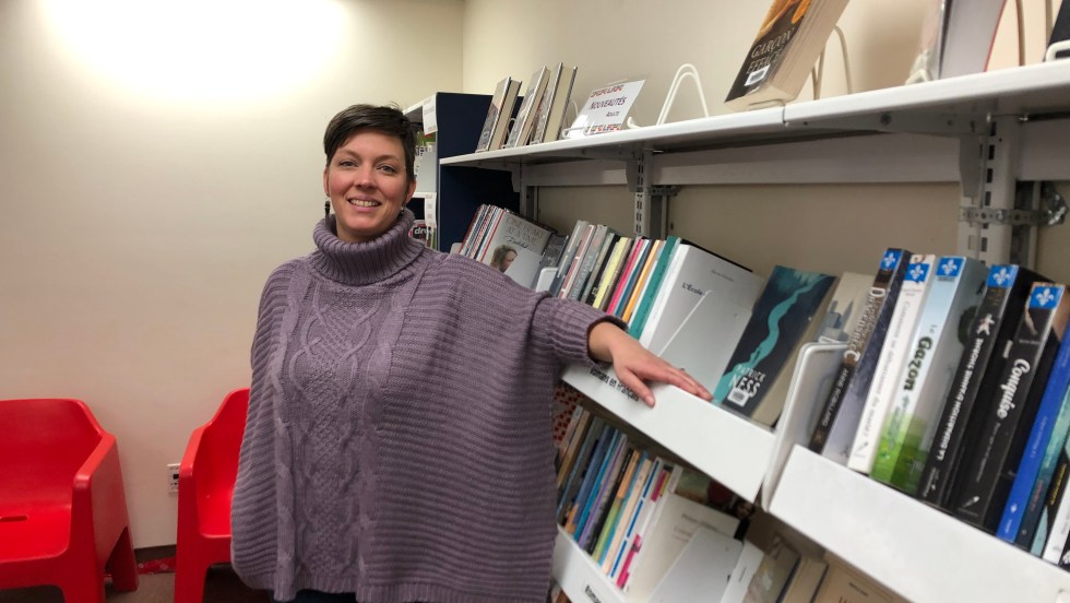 Mélanie Bossé responsable bibliothèque Ahuntsic devant un rayon de livres