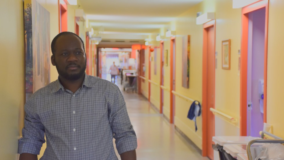 Un préposé aux bénéficiaires regarde au loin dans un couloir de CHSLD