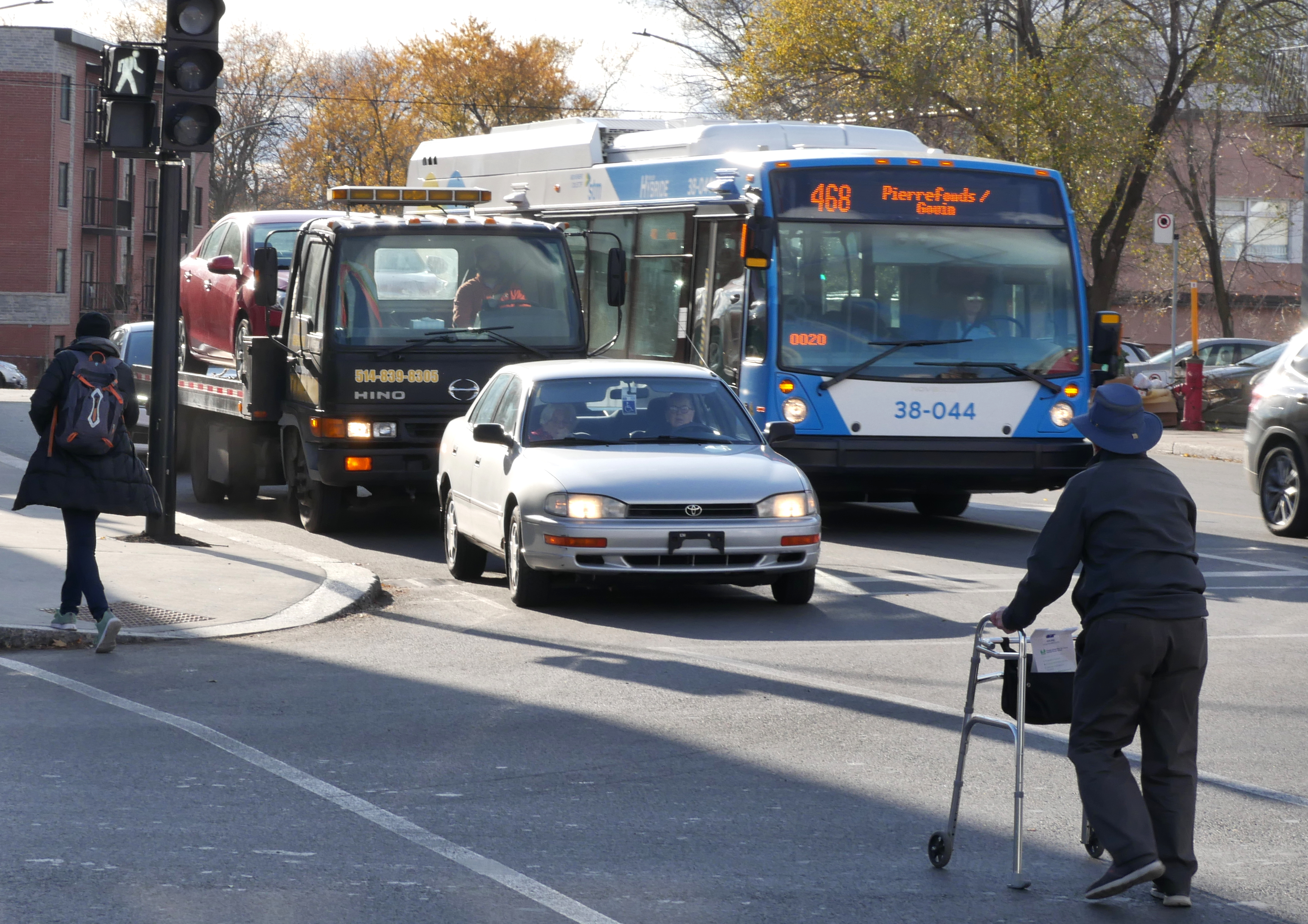 Piéton personne âgée en marchette traverse à un feu de circulation