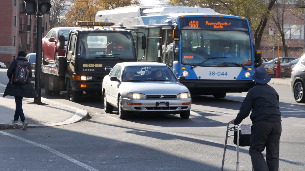 Piéton personne âgée en marchette traverse à un feu de circulation