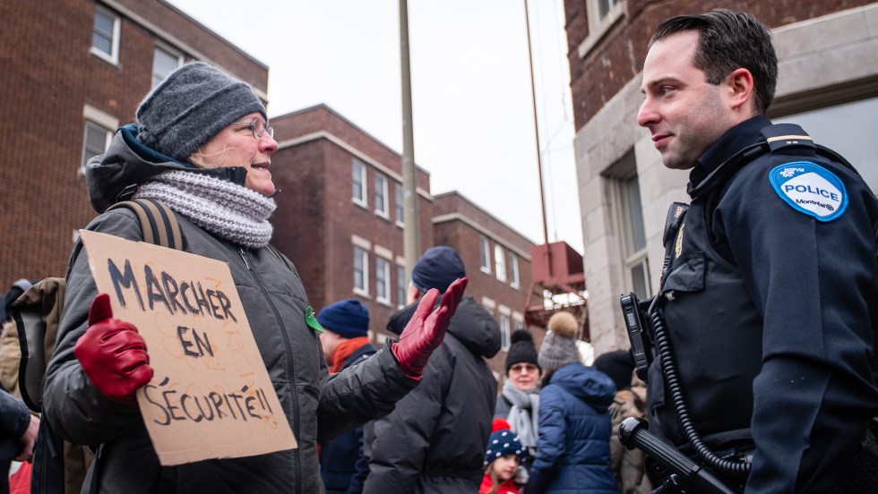 Une citoyenne s'adresse à un agent du SPVM, dimanche, à un rassemblement citoyen pour exiger une révision du Code de la sécurité routière.